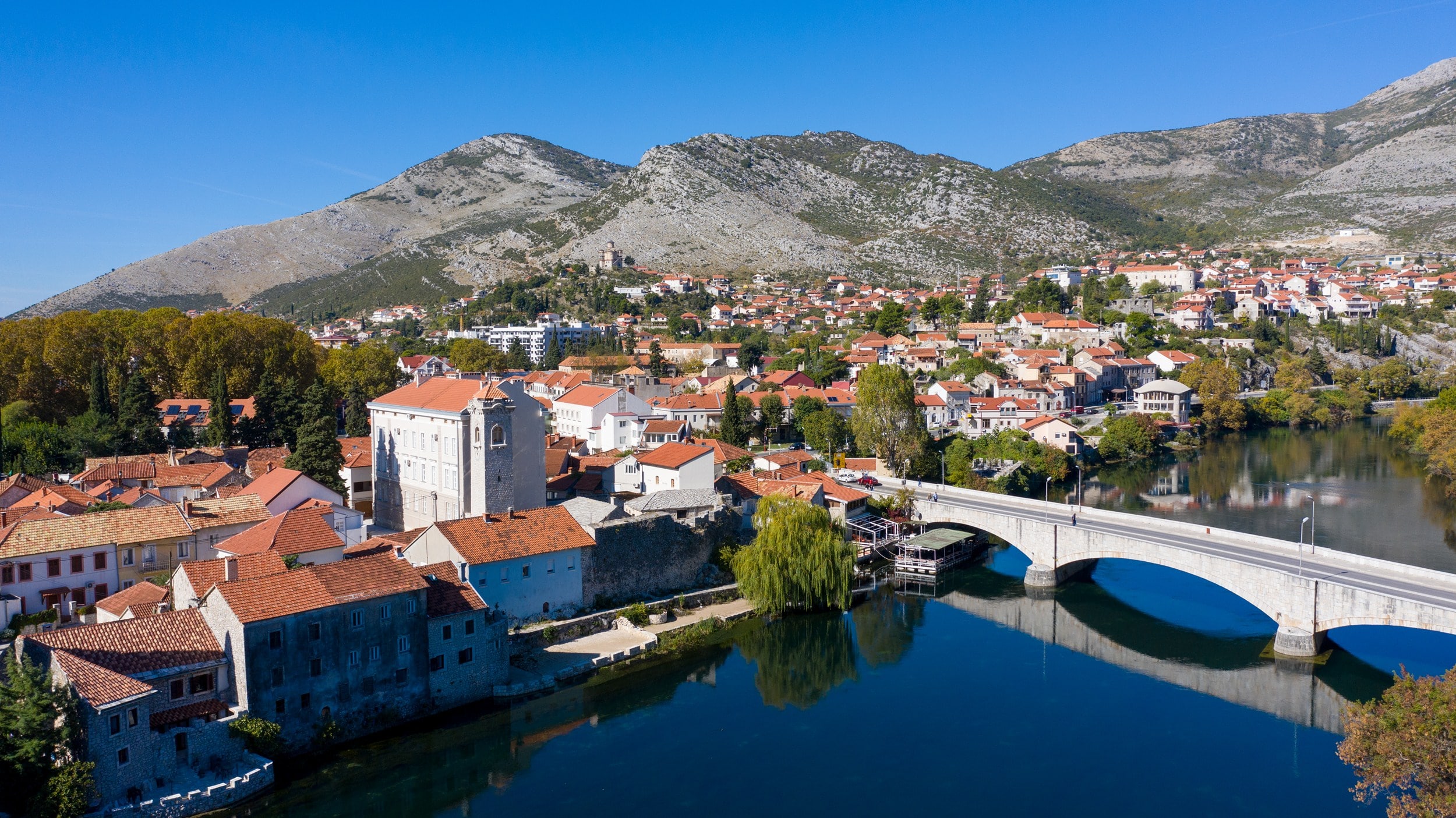 Trebinje, rijeka, kameni most i hercegovačka brda u zlatnom svjetlu
